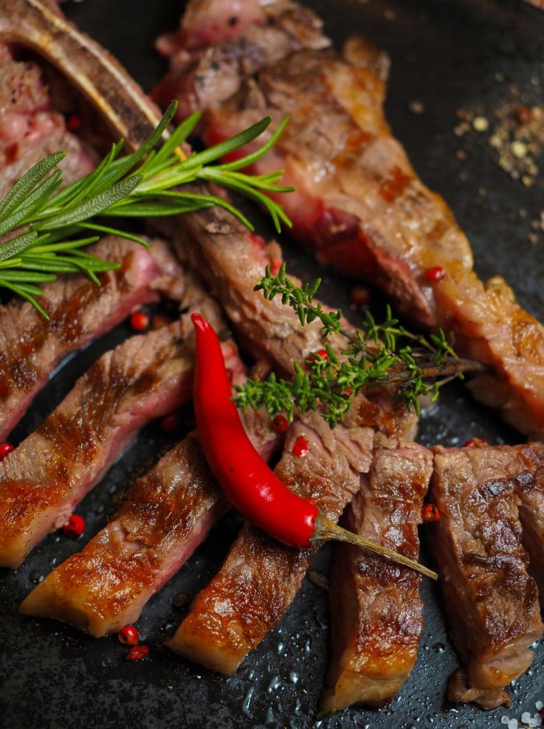 Sliced grilled Tuscan steak with rosemary, thyme and chili pepper