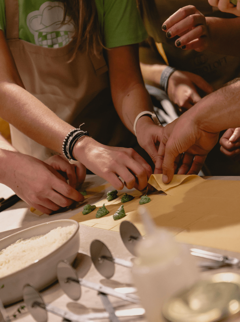 Group of colleagues shaping ravioli together during a team building cooking experience