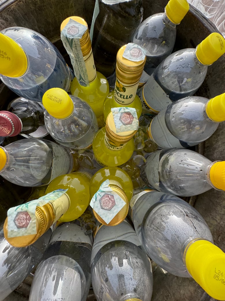 Chilled bottles of limoncello and local liqueurs arranged in an ice bucket beverage station