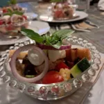 Appetizer in small glasses with tomato, mozzarella and red onion on a buffet