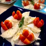 Caprese salad with mozzarella and cherry tomatoes, basil, and oregano.