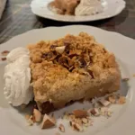 Apple tart with chopped almonds and cream, a dessert for an event