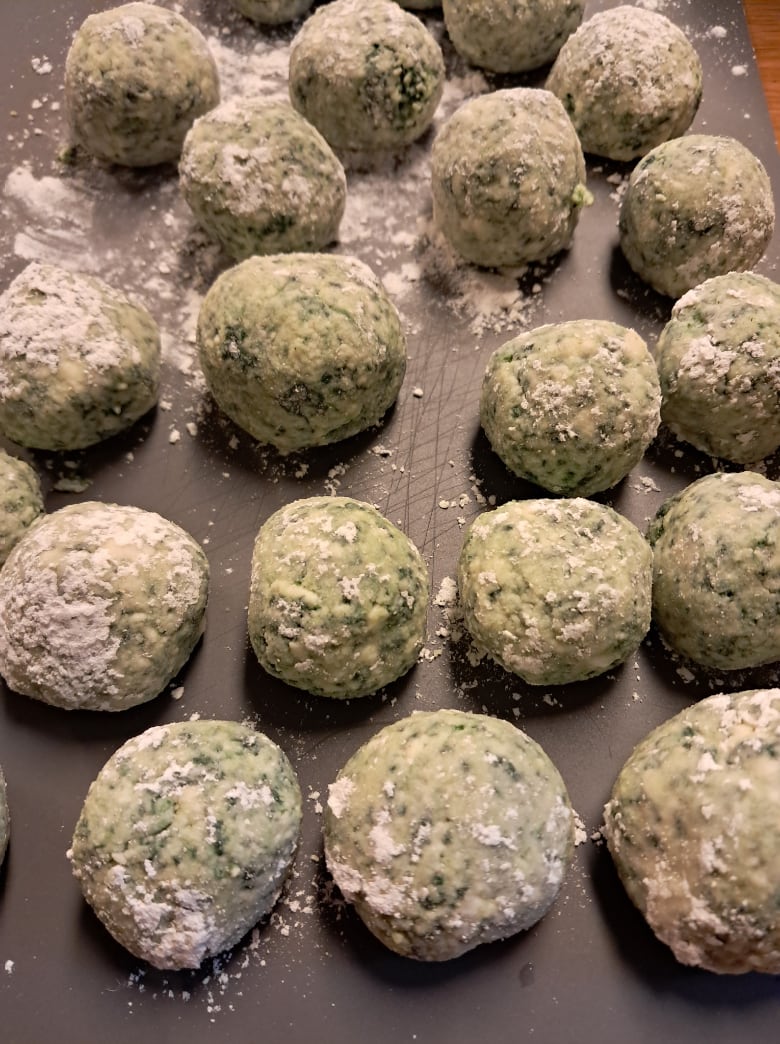 Rows of homemade spinach and ricotta gnudi dusted with flour, from the Tuscan pasta cooking class