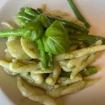 Short pasta with pesto, green beans and fresh basil leaves