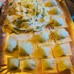 Vassoio di tagliatelle alle erbe fresche e ravioli ripieni fatti durante un corso di pasta toscana