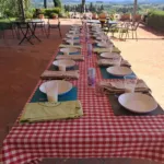 Lungo tavolo all'aperto per un pranzo di cucina con vista sulle colline del Chianti