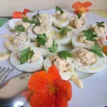 Uova sode ripiene di tonno guarnite con fiori di nasturzio, un antipasto per un evento